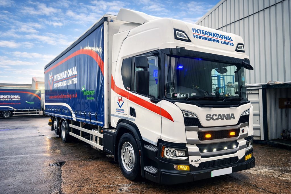Large white and blue freight truck with IFL logo for international logistics.